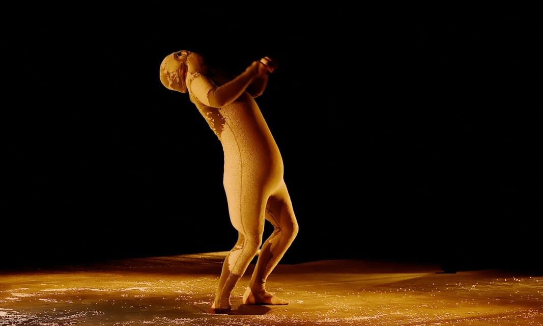 Une danseuse dans un halo de lumière dorée.
